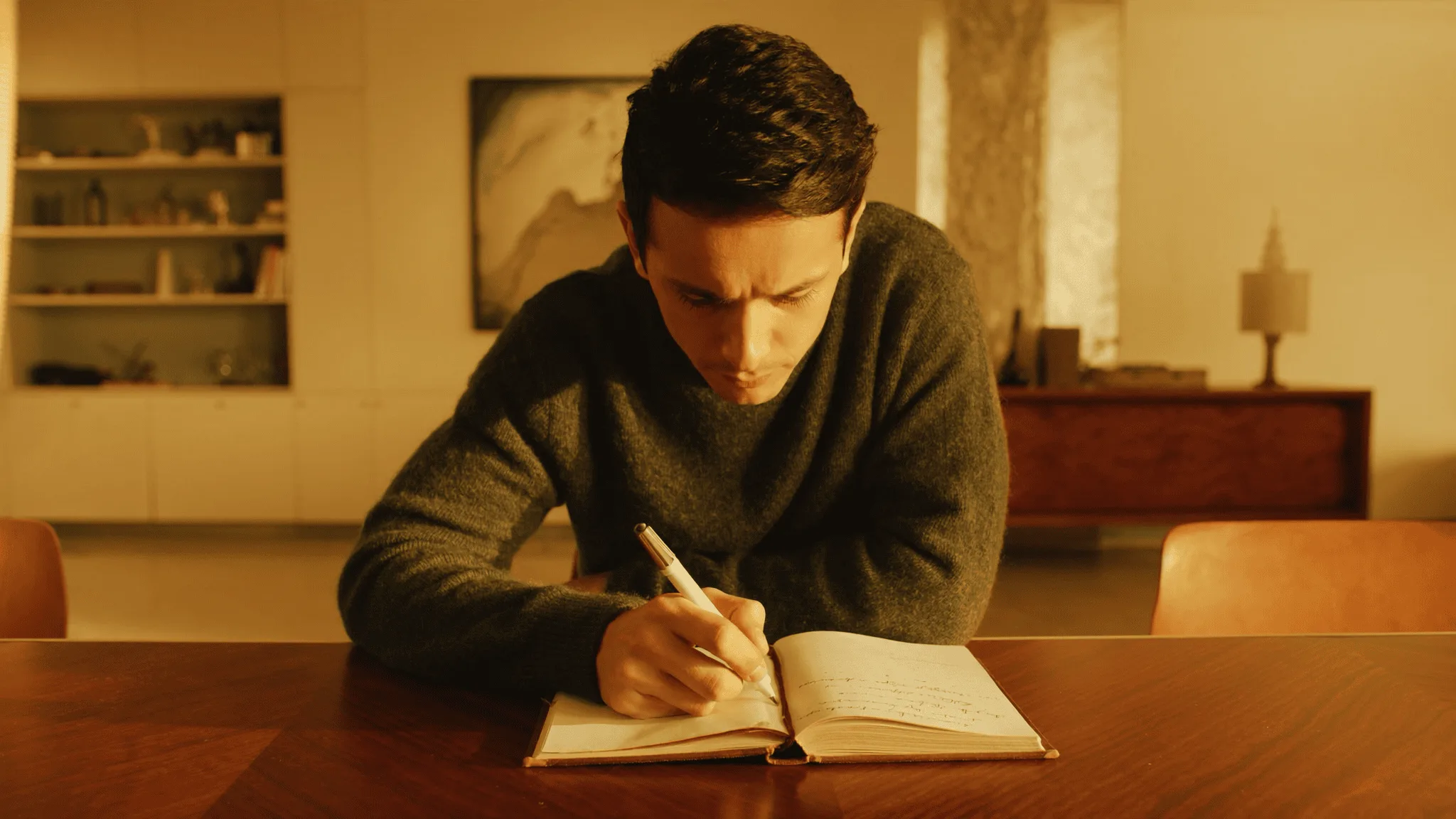 A young man in calm grounded patient consideration of a long-horizon plan at his conference table.